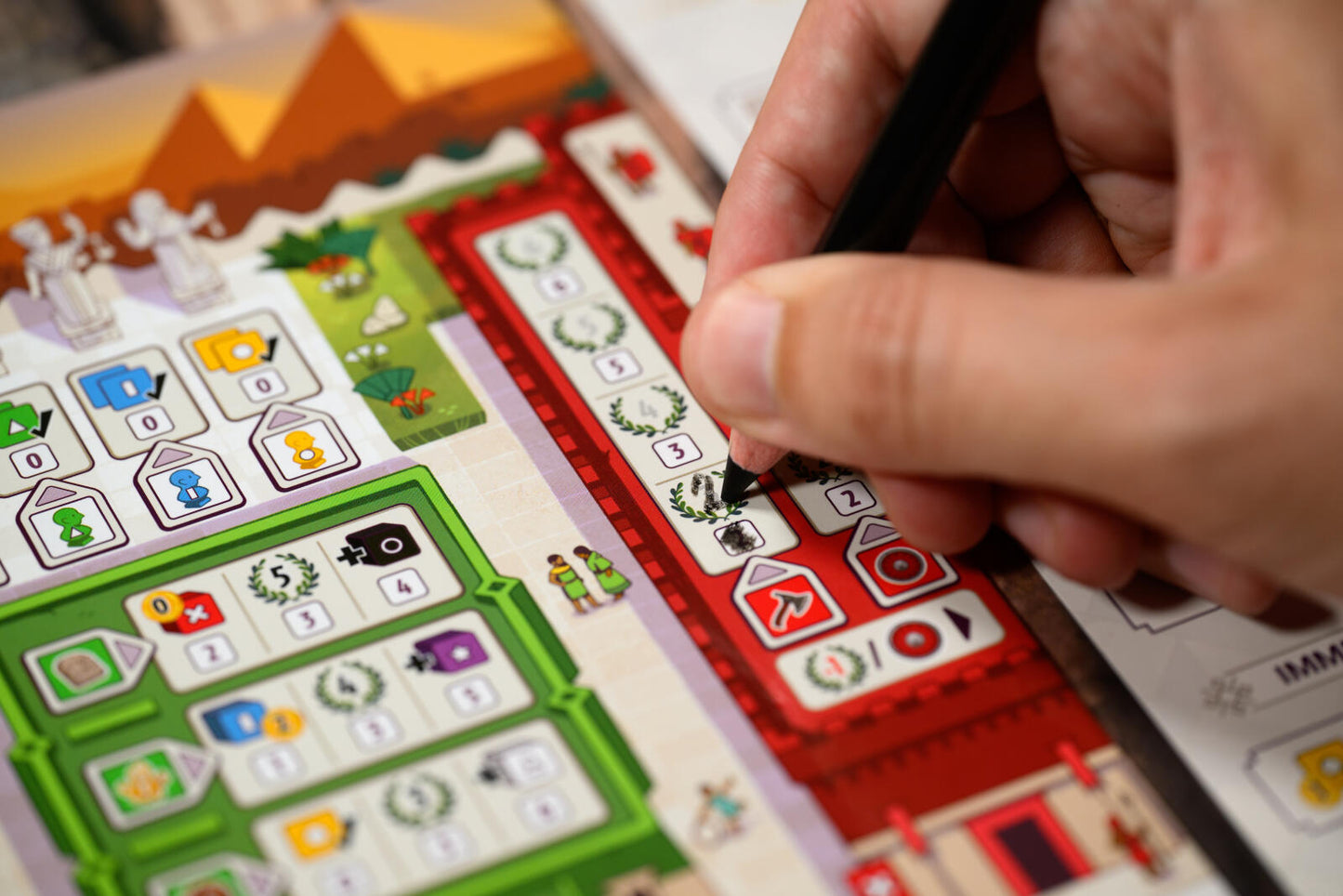 Hand holding a pen over a colorful educational chart with symbols