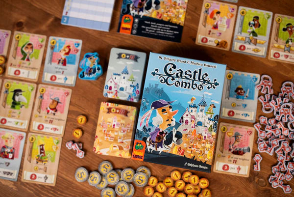 Castle Combo Board game components including cards and dice on a wooden surface with 'Castle Combo' box.