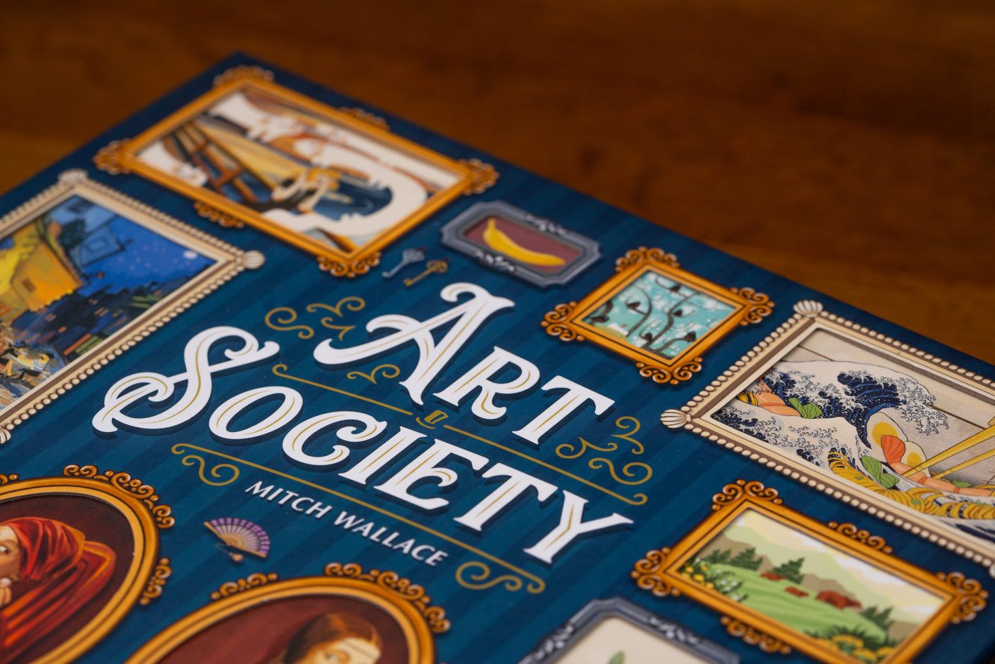 Board game box for 'Art Society' by Mitch Wallace with artistic illustrations on a dark background.