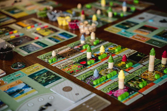 Board game with colorful pieces and cards on a wooden table