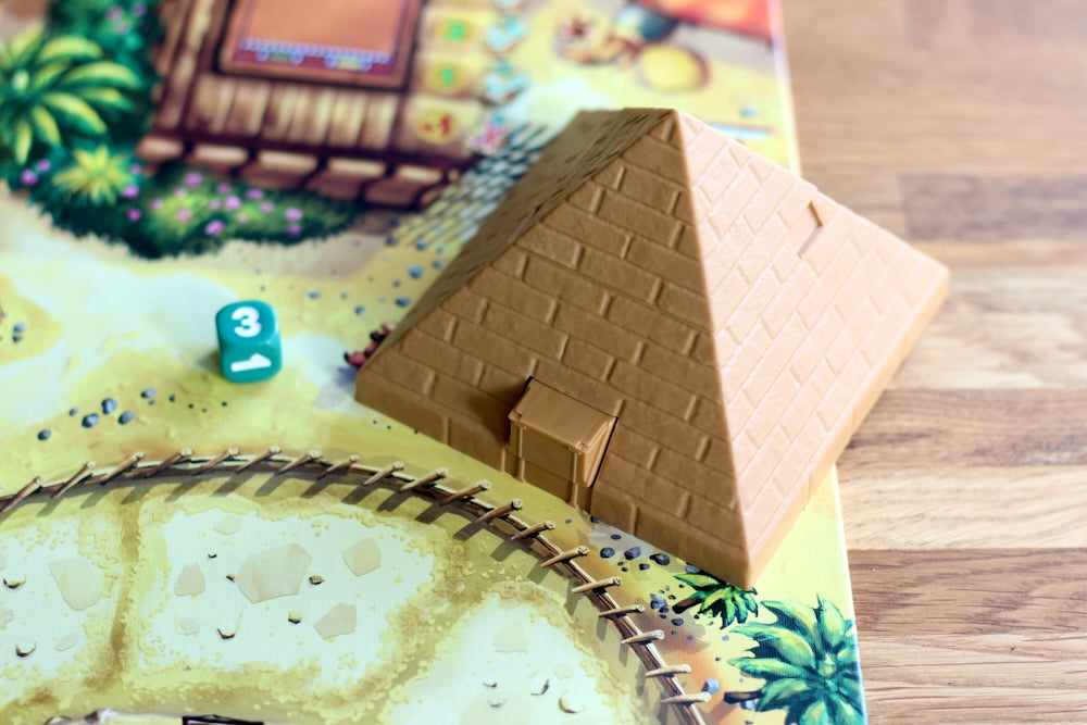 Pyramid-shaped game piece on a board game map for Camel Up the board game.