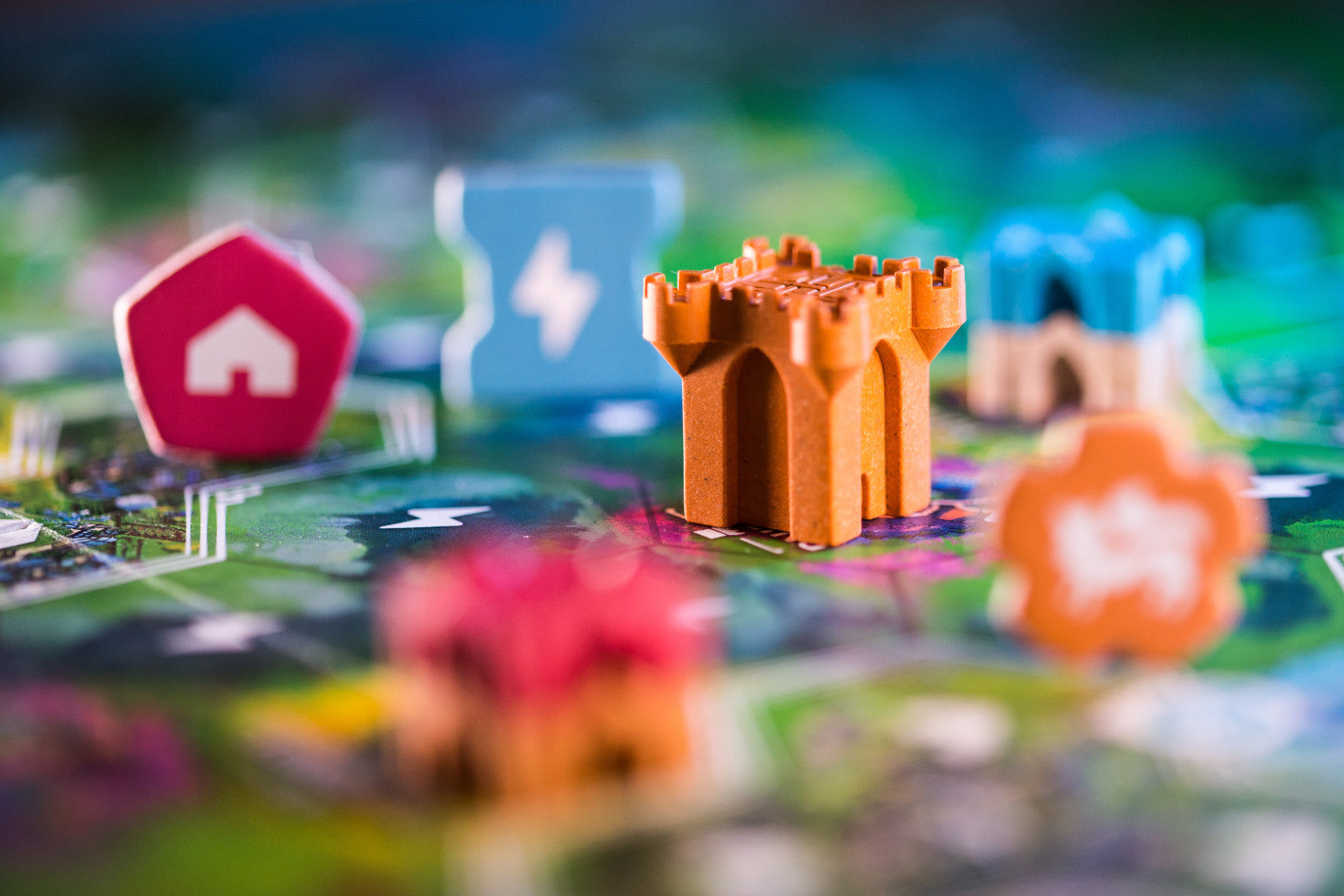 Rebirth Colorful board game pieces on a game board with a castle piece in focus.