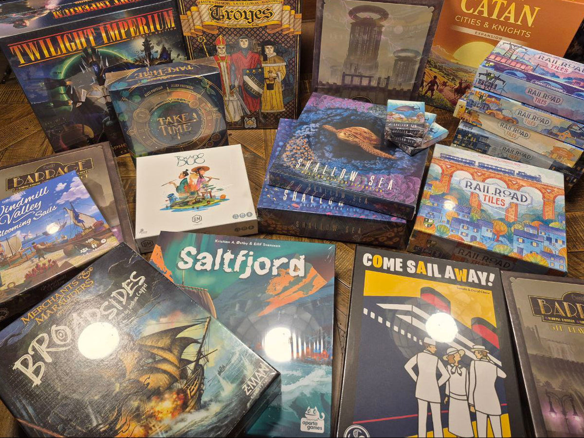 Collection of board game boxes on a wooden surface