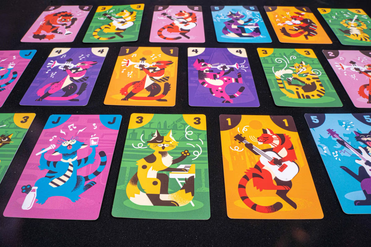Colorful cat-themed playing cards arranged on a dark surface