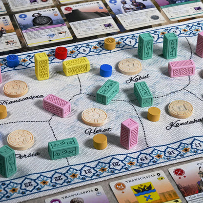 Pax Pamir Board game pieces and cards on a game board with colorful markers and text.