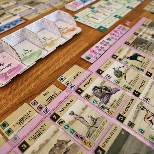 Board game cards with animal illustrations on a wooden table
