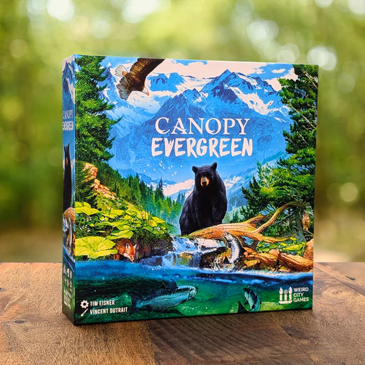 Board game box titled 'Canopy Evergreen' with a bear and nature scene on a wooden surface.
