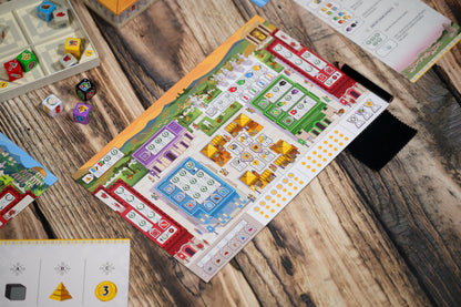 Board game with colorful tiles and dice on a wooden surface