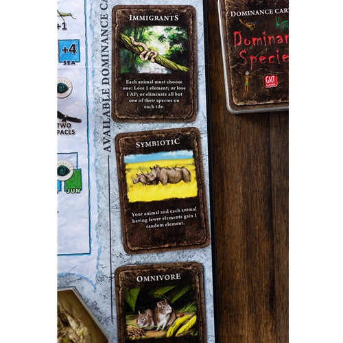 Dominant Species Board game cards with animal illustrations and text on a wooden surface