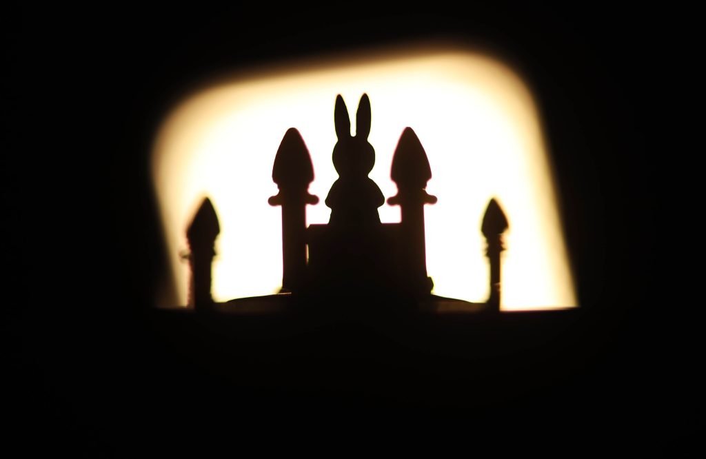 Bunny Kingdom Silhouette of a rabbit figure with a sunset or sunrise in the background