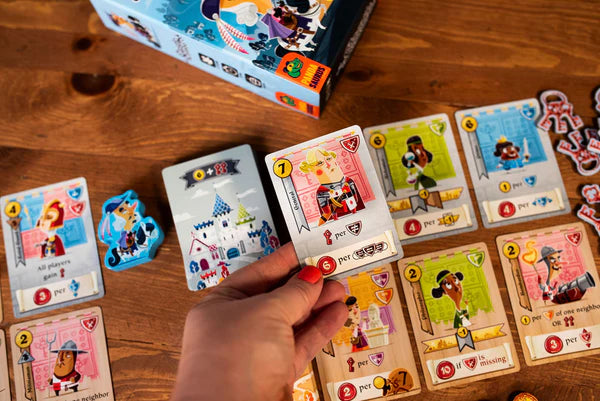 Hand holding a Castle Combo card from a colorful board game on a wooden table