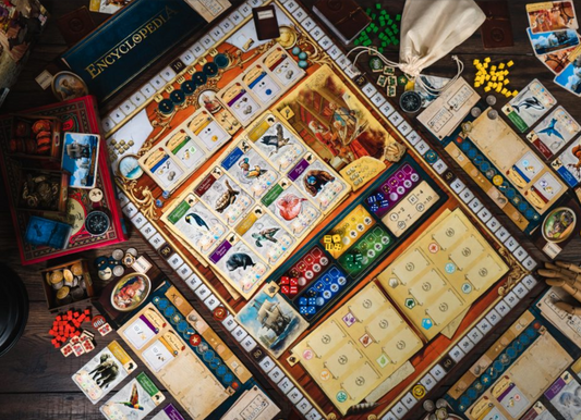 Encyclopedia Board game with various components on a wooden surface