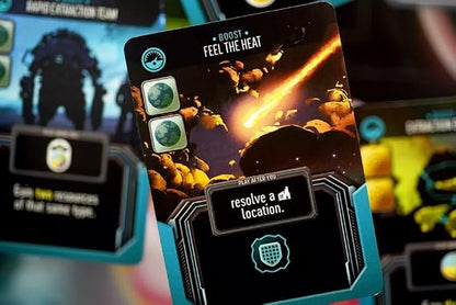 A close-up of a collectible card from the board game How to save a world, featuring a space-themed illustration with a bright orange meteor shower and the text 'BOOST FEEL THE HEAT' and 'resolve a location.'.