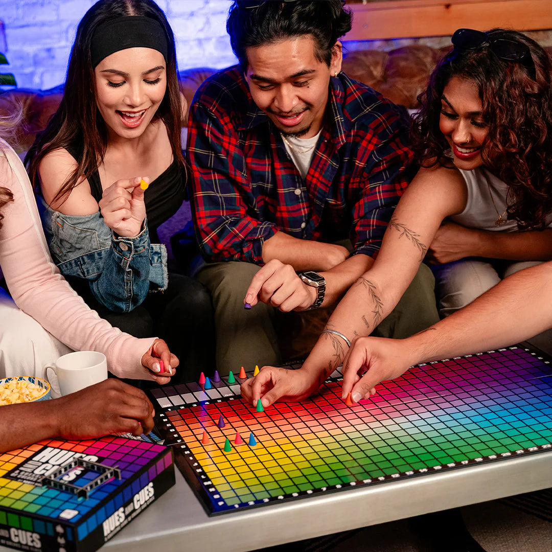 Group of people playing a Hues and Cues board game together.
