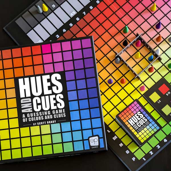 Colorful game board with 'Hues and Cues' packaging and components on a dark surface.