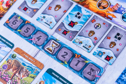 Close-up of a board game with cards featuring numbers, symbols, and animal illustrations.