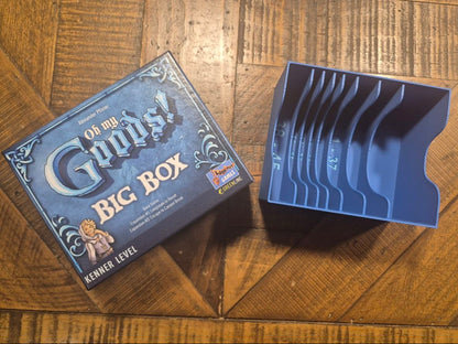A blue plastic card tray organizer and its branded box from The Game of Thrones 'Bronze Age' set, placed on a wooden floor.