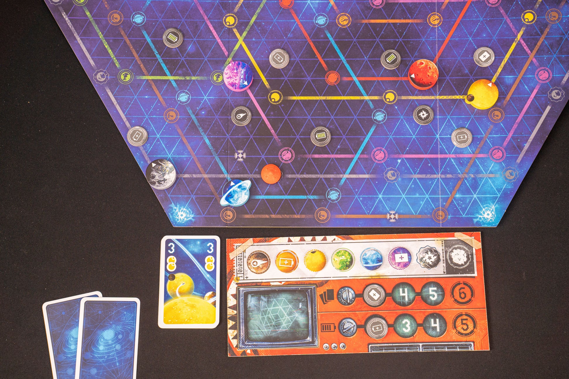 Orbit Board game components including a colorful game board, cards, and character cards on a dark surface.