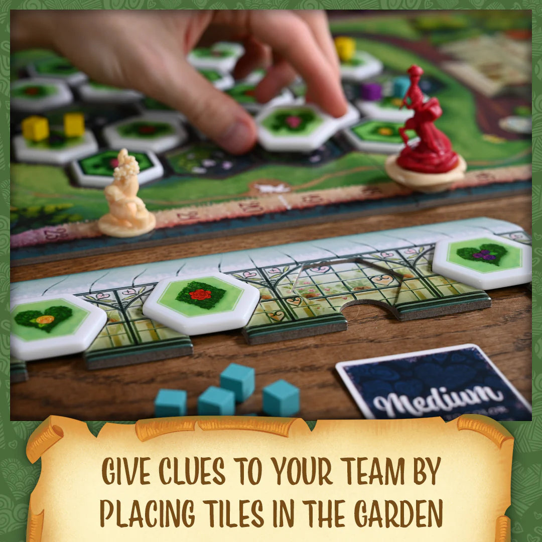 Paint the Roses Board game with tiles and pieces on a wooden surface, featuring text 'Give clues to your team by placing tiles in the garden'.