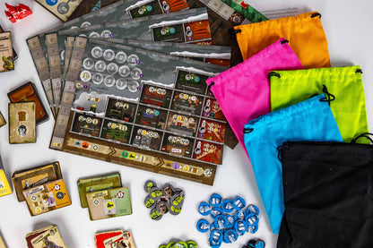 Resurgence Board game components and storage bags arranged on a white surface, including a game board, cards, tokens, and drawstring pouches in orange, pink, neon green, blue, and black.