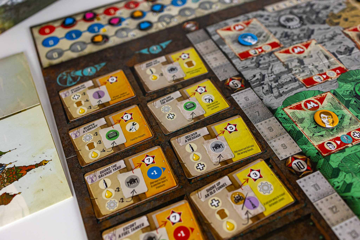 Resurgence board game setup showing multiple wooden play cards, colored tokens, and illustrated game boards on a tabletop.