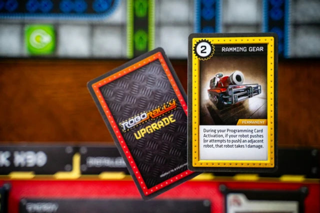 Robo Rally Two game cards with text and graphics on a blurred background