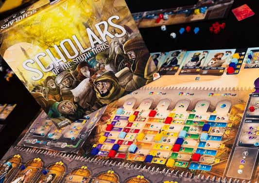 Scholars of the South Tigris Board game packaging with colorful tiles and character illustrations on a dark background