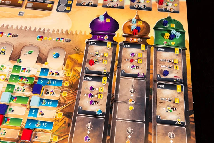 Scholars of the South Tigris Board game cards with colorful symbols and numbers on a wooden surface