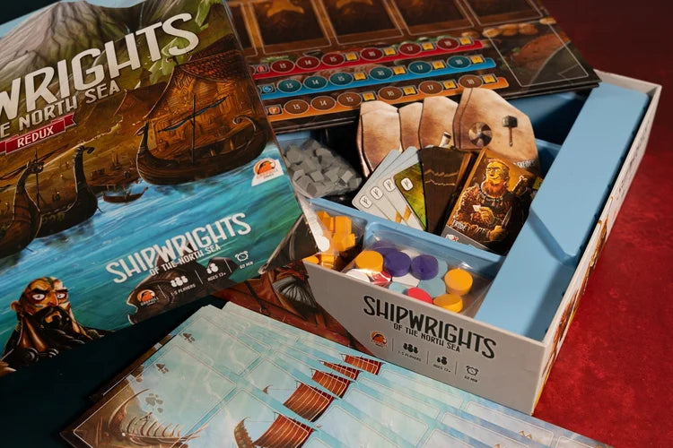 Shipwrights North Sea Board game 'Shipwrights' with components and packaging on a red surface