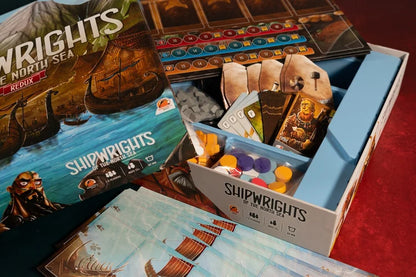 Shipwrights North Sea Board game 'Shipwrights' with components and packaging on a red surface