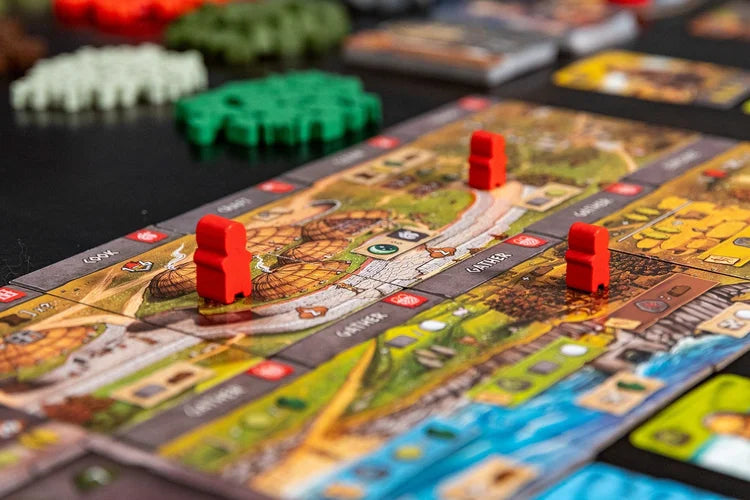 Skara brae Board game with colorful tiles and red player pieces on a dark surface