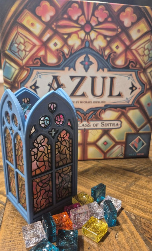 Azul game piece with colorful tiles on a wooden surface, featuring the Azul game box in the background.