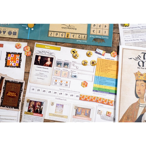 Board game components laid out on a wooden surface, including a game board, cards, tokens, and a book or box cover featuring a crowned figure.