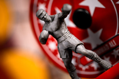 Ali boxing figure in front of a red and white circular logo