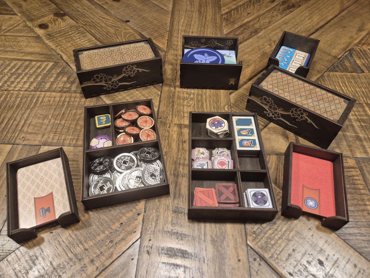 3DLevelup Board game timber organiser with collection of card game components in black boxes on a wooden surface