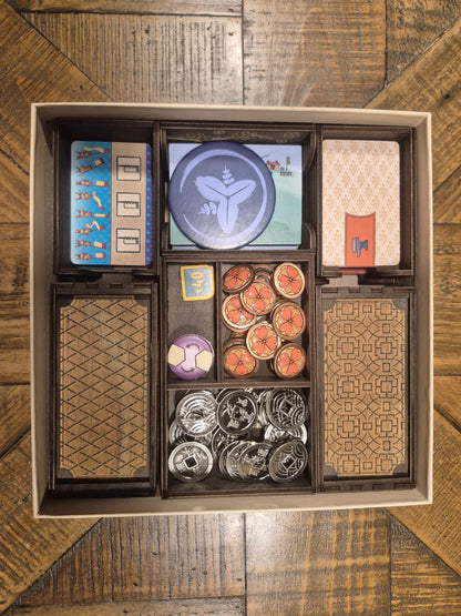 3DLevelup Board game timber organiser with collection of board game components including cards, tokens, and  a box on a wooden surface.