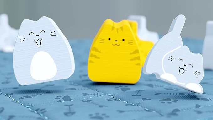Boop board game with Three cat-shaped night lights in white, yellow, and gray on a blue surface.
