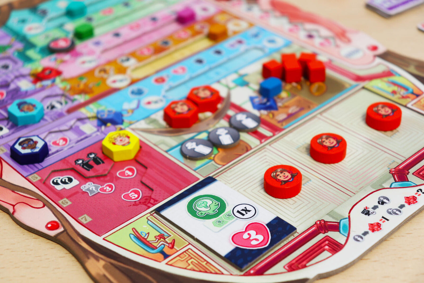 Coming of Age Colorful board game with various tokens and cards on a wooden surface