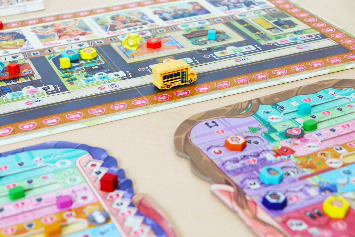 Coming of Age Colorful board game pieces on a table with a bus toy.