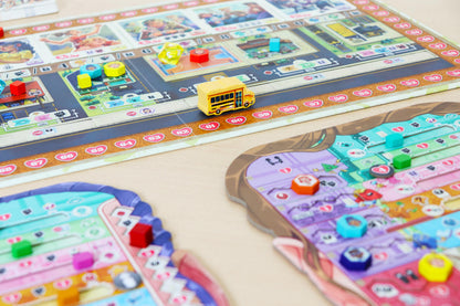 Coming of Age Colorful board game pieces on a table with a bus toy.