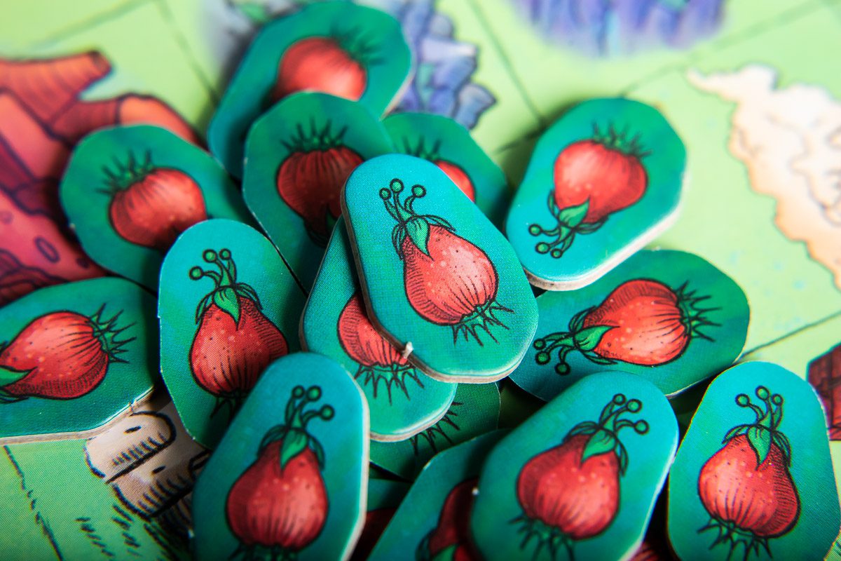 Close-up of game pieces with red pears on green backgrounds
