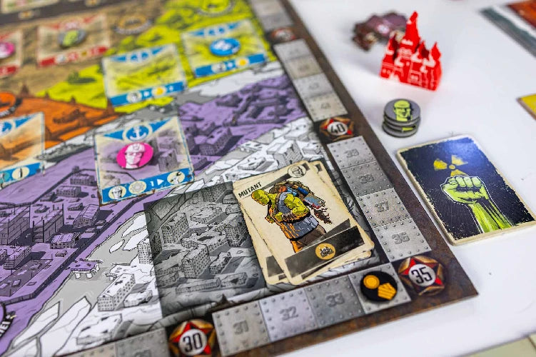 Resurgence board game in progress on a white tabletop. The board has illustrated sections, silver-colored track segments, player tokens, cards, and small red, green, black, and yellow game pieces.
