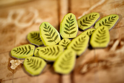 Green leaf-shaped stamps on a wooden surface