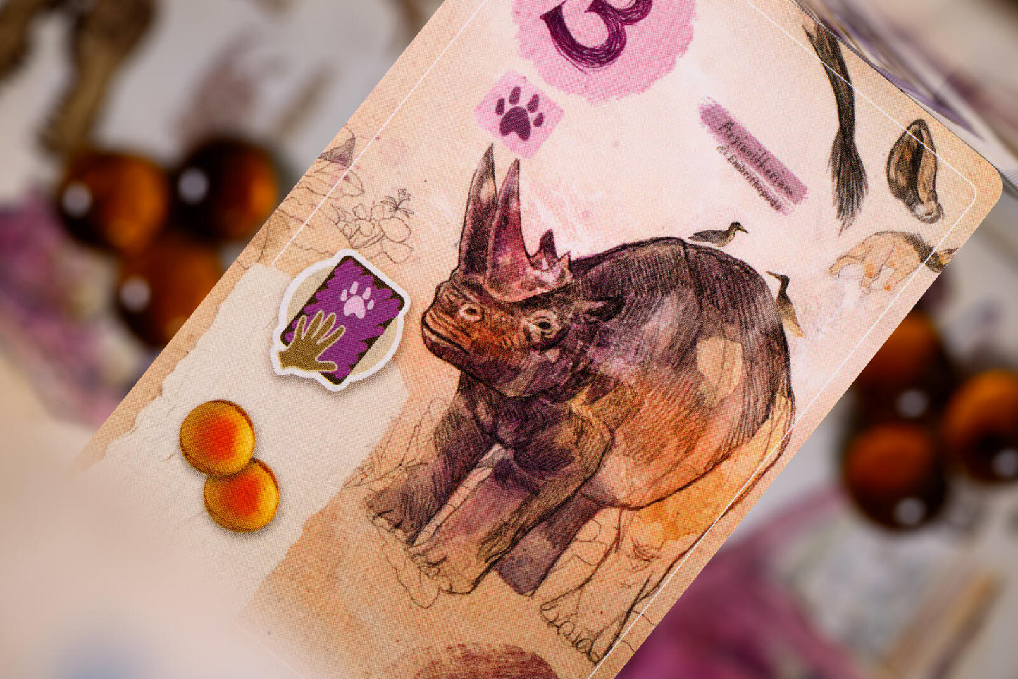 Card with a rhinoceros illustration and paw print symbols on a blurred background