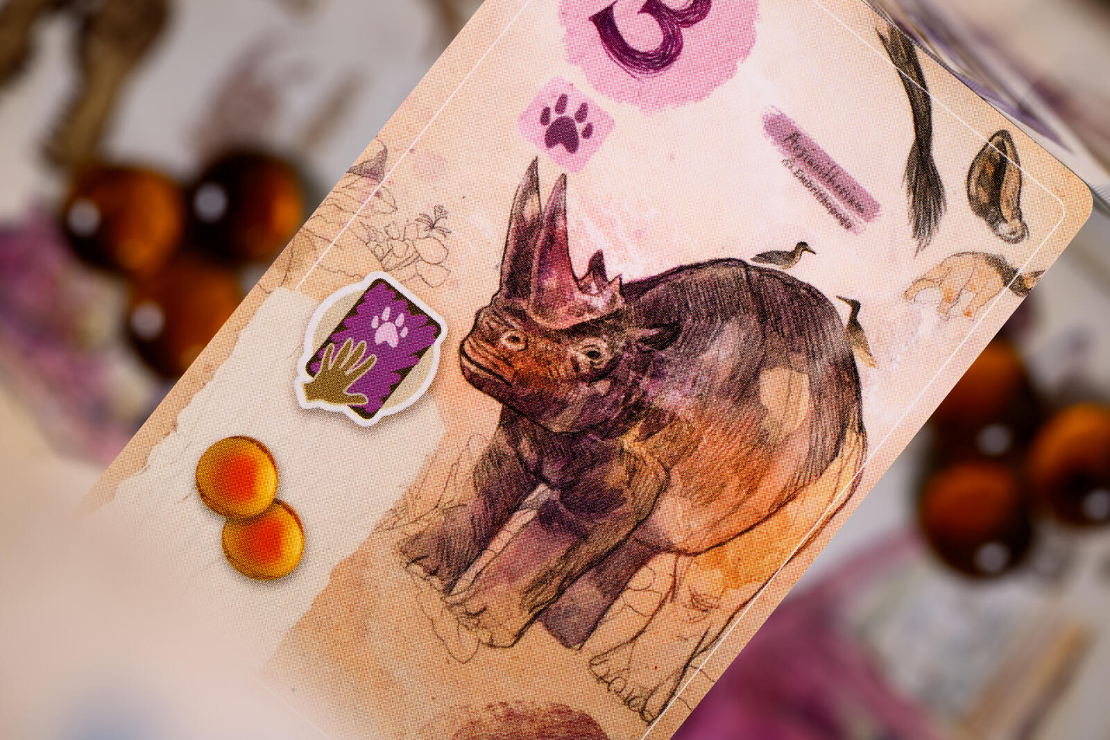 Card with a rhinoceros illustration and paw print symbols on a blurred background