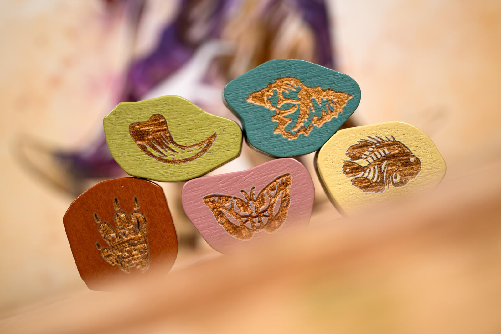 Set of colorful wooden stamps with butterfly designs on a blurred background