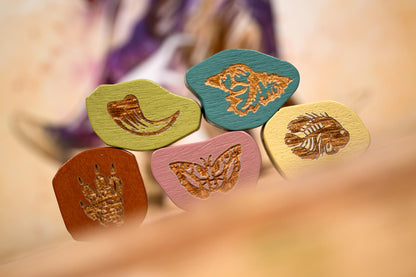 Set of colorful wooden stamps with butterfly designs on a blurred background