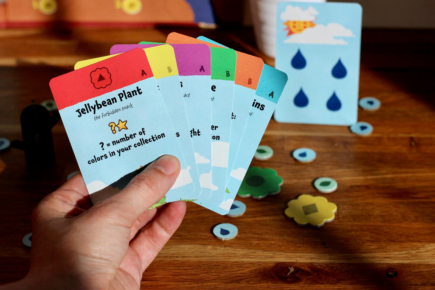 Hand holding educational cards with colorful designs on a wooden surface