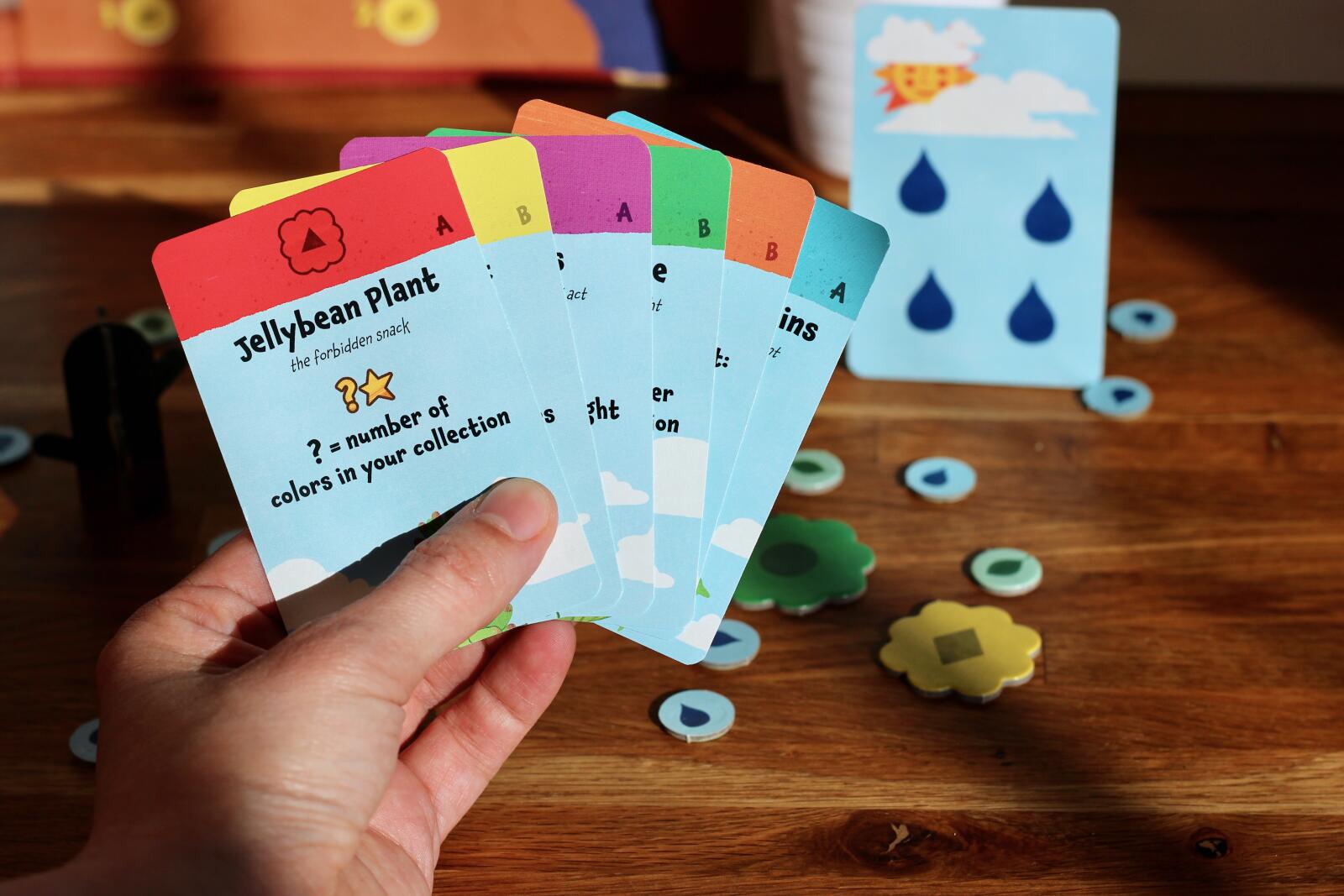 Hand holding educational cards with colorful designs on a wooden surface