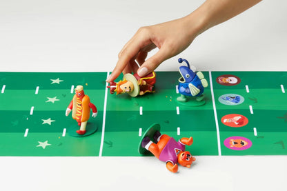 Hot Streak Toy figures on a green game board with a hand interacting with one of them.